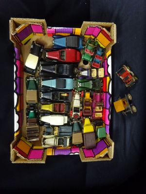 une boîte remplie de petites voitures de toutes sortes posée sur une surface noire