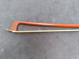 a close up of a wooden bow on a gray surface