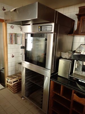 une cuisine équipée d'une cuisinière, d'un four, d'un micro-ondes et de placards