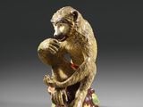 une image représentant une statue de singe assis sur une souche d'arbre