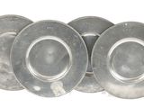 three silver plates are stacked on top of each other on a white surface