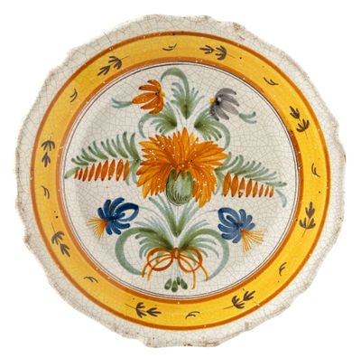 a yellow and blue plate with flowers and birds on it