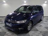 La Volkswagen Touran bleue est garée sur un sol en carrelage à damier.