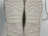 pair of white sneakers with white soles on a white surface