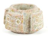a stone bowl with a design on it on a white surface