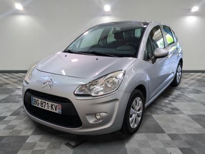 la petite voiture argentée est garée sur un sol en damier