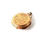 a small gold pocket watch on a white surface