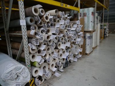 de nombreux rouleaux de papier toilette posés sur un support dans un entrepôt