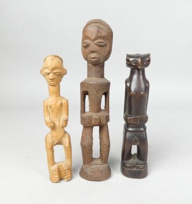 three wooden figurines of different shapes and sizes on a white surface