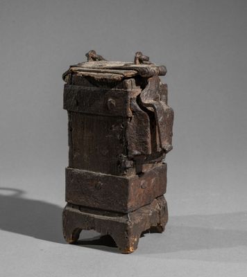 an old wooden box sitting on top of a table next to a shadow