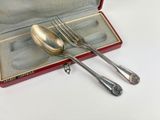 a silverware set in a red case on a white surface
