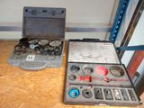 une trousse à outils posée par terre à côté d'une boîte à outils