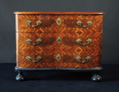 une commode ancienne avec un plateau en bois et des poignées en laiton
