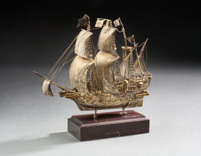 maquette en bois sculpté représentant un voilier, posée sur un socle en bois