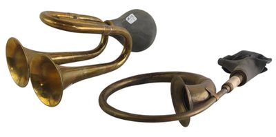 two brass trumpets and a black cord on a white background