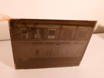 an old photo of a person holding up a picture of a building