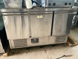 two stainless steel refrigerators sitting on a pallet in a kitchen