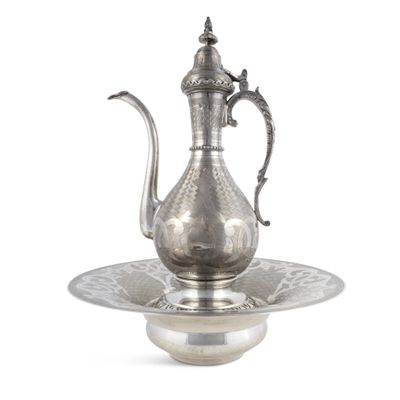 une théière ancienne en argent posée sur une soucoupe, avec une autre soucoupe en dessous