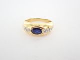 une bague en or jaune sertie d'une pierre bleue et de diamants