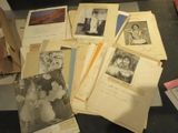 une pile de vieilles photos posée sur une table, à côté d'une pile de papiers