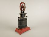 une petite machine rouge et noire posée sur une surface blanche