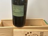 caisse à vin en bois sur laquelle est posée une bouteille de vin