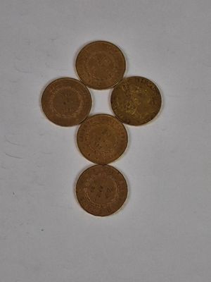 four coins are arranged in a triangle on a white surface