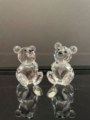 figurines en cristal représentant deux oursons assis sur une surface noire