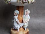 deux figurines d'enfants assis sur un socle