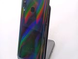 a close up of a phone on a stand on a white surface