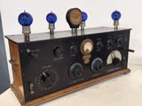 an old fashioned radio with four blue bulbs on top of it