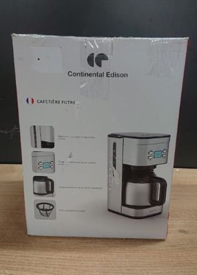packaging of a coffee maker on a wooden table with a black background