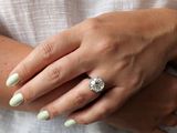 a woman wearing a white shirt and a ring on her finger