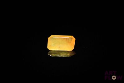 une image représentant un quartz jaune posé sur une surface noire