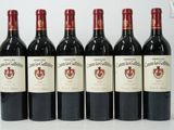 six bottles of red wine lined up in a row on a table
