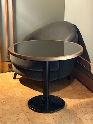 a round table with a glass top on a wooden floor