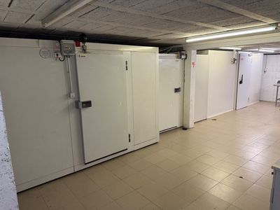 plusieurs réfrigérateurs dans une pièce au sol carrelé