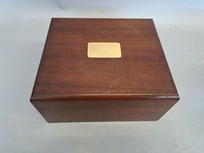 une image représentant une boîte en bois dont le couvercle est orné d'une plaque en laiton