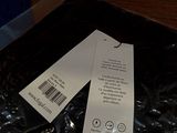 a black bag with a tag on it sitting on a table