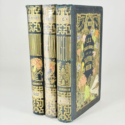 two books are sitting on top of each other on a white surface