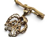 une image montrant un gros plan d'un collier en or orné d'une branche d'arbre