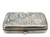 an antique silver cigarette case with a design on the front