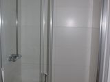 a small bathroom with a glass shower door next to a sink