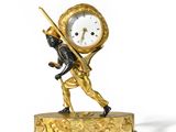 une horloge en or sur laquelle figure un homme tenant un bâton