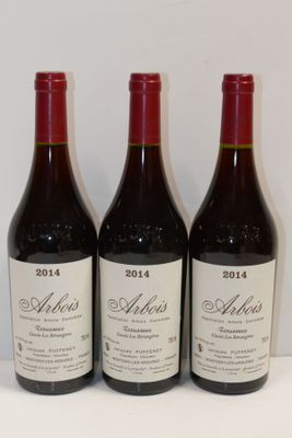trois bouteilles de vin sont alignées sur une table