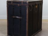 a black trunk sitting on the floor in a room