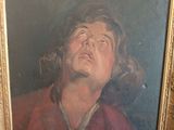 portrait of a man in a red shirt looking up in a gold frame