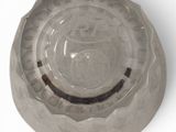 a glass bowl with a hole in it on a white surface