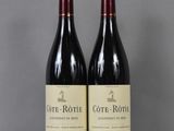 two bottles of wine sitting on top of a table next to each other