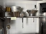 many pots and pans on the shelf in the kitchen